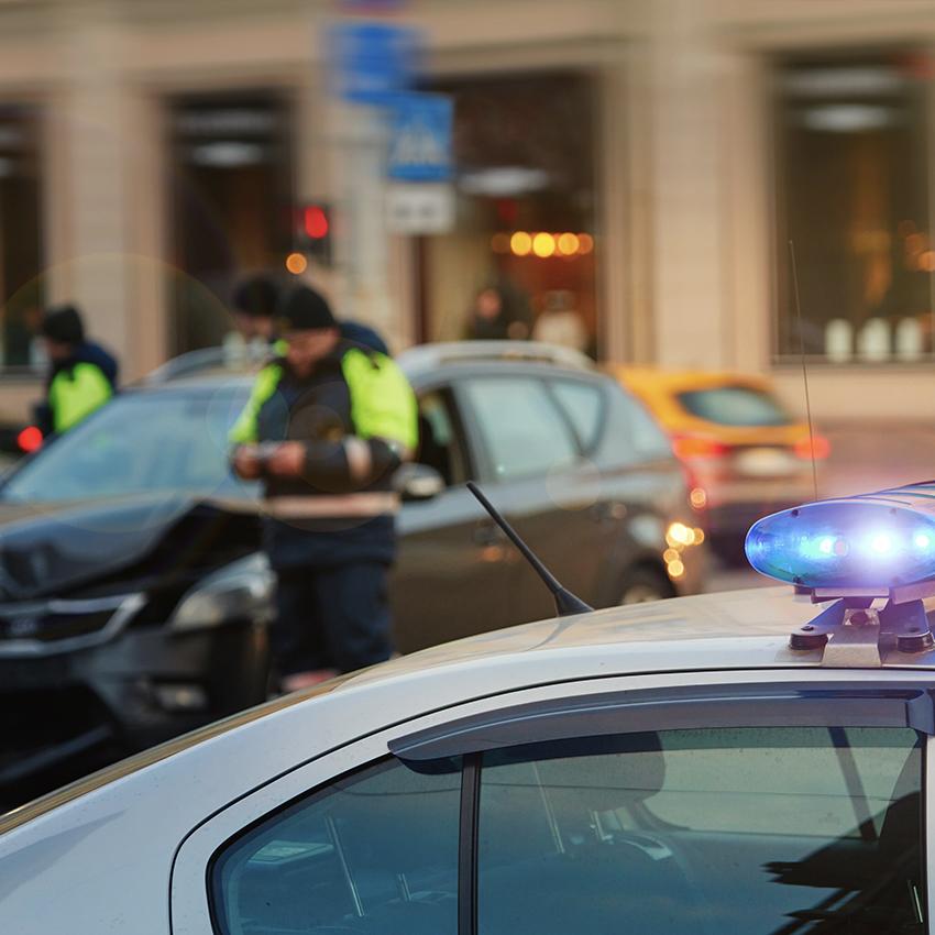 scene of a car crash with police car and police present