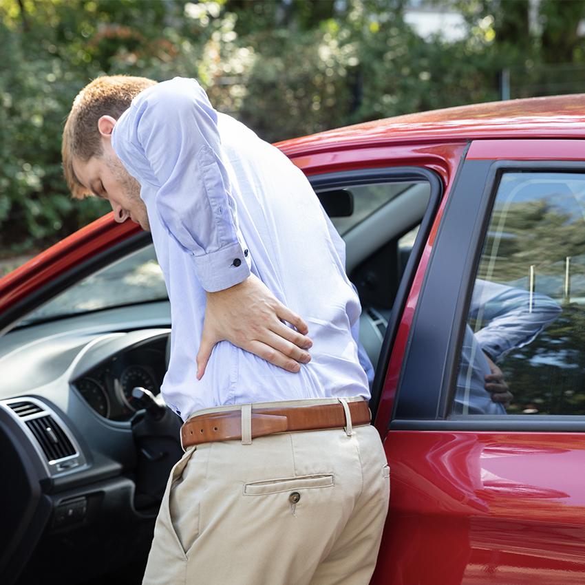 man holding back in pain after car accident