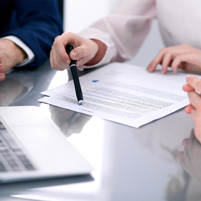 lawyers going over paperwork with laptop present