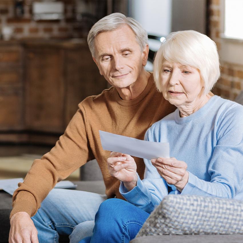 man and woman sitting together looking at bills