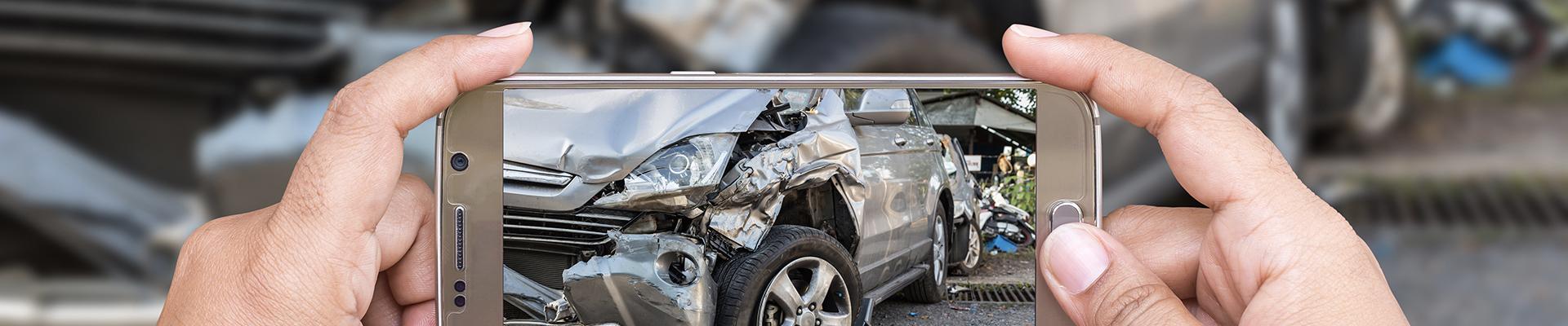 man taking picture of accident with smartphone