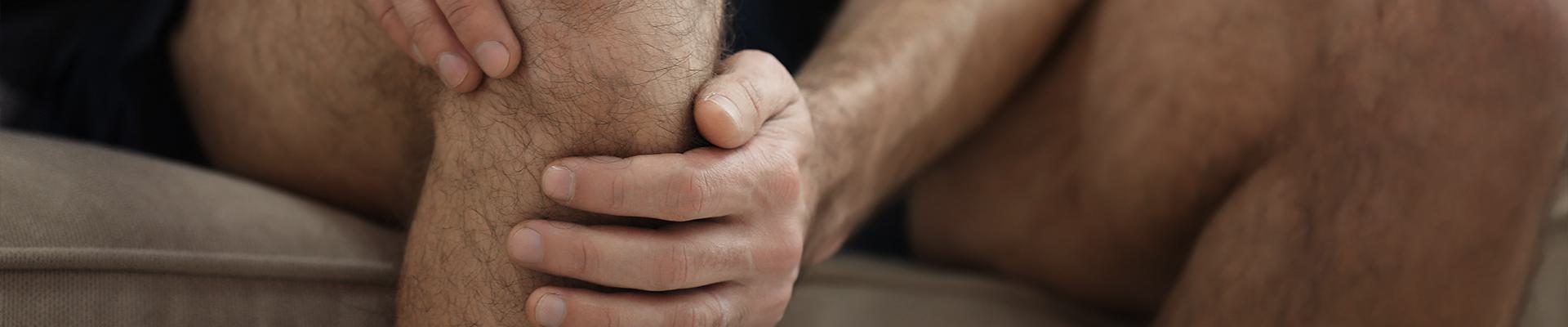 closeup of man holding knee in pain